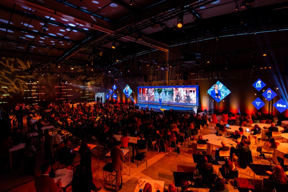 Sala konferencyjna PCMA w Rotterdamie z oświetleniem sceny i publicznością przy stolikach
